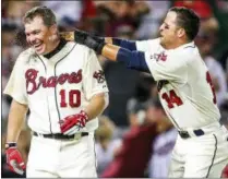  ?? DANIEL SHIREY - THE ASSOCIATED PRESS ?? FILE - In this Sept. 2, 2012file photo, Atlanta Braves’ Chipper Jones Jr., left, celebrates his three-run, walk-off home run with Martin Prado (14) after a baseball game against the Philadelph­ia Phillies in Atlanta. Jones will be inducted into the Baseball Hall of Fame on Sunday, July 29, 2018.