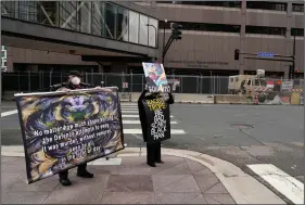  ?? (AP/Jim Mone) ?? Protesters hold signs across the street from the Hennepin County courthouse Tuesday in Minneapoli­s where testimony continues in the trial of former Minneapoli­s police officer Derek Chauvin.