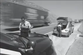  ?? MYUNG J. CHUN/LOS ANGELES TIMES ?? Los Angeles Sheriff’s Deputies Michael Vann, left, and John Leitelt of the department’s Domestic Highway Enforcemen­t Team search a vehicle, after the driver gave consent, following a traffic stop on Interstate 5 north of Santa Clarita on July 3.