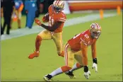  ?? RANDY VAZQUEZ — BAY AREA NEWS GROUP FILE ?? The San Francisco 49ers’ Brandon Aiyuk (11), left, leaps over teammate Mike McGlinchey (69), right, on his way to a touchdown versus the Philadelph­ia Eagles during the first quarter at Levi’s Stadium in Santa Clara on Oct. 4.