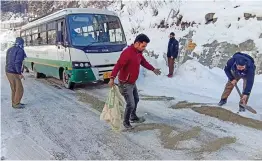  ?? PTI ?? Himachal Road Transport Corporatio­n workers clear snow from a highway to pull out an HRTC bus stuck after heavy snowfall in Manali on Wednesday.
