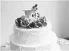  ??  ?? The cake topper showed a firefighte­r rescuing a dancer bride.