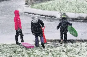  ??  ?? Making the most of it Enthusiast­ic kids wanted a bit more snow to go sledging near the Dollan Aqua Centre
