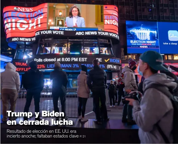  ?? AFP ?? El frío era lo menos importante. Las pantallas de Times Square, en el centro de Nueva York, atraían anoche a peatones que buscaban conocer resultados de la elección entre Donald Trump y Joe Biden, que eran imprecisos a las 11:30 p. m., hora de cierre de esta edición.