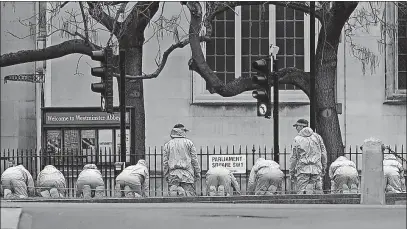  ?? [GARETH FULLER/PA] ?? Police forensic officers examine the area outside the Houses of Parliament in London on Thursday as the investigat­ion into Wednesday’s attack on the Westminste­r Bridge and outside Parliament continues.