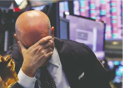  ?? RICHARD DREW / THE ASSOCIATED PRESS FILES ?? This pretty much sums up the situation on the stock markets the past few weeks as a trader on the New York Stock
Exchange holds his head earlier this month. The market sell-off has cost Canada’s pension funds billions.