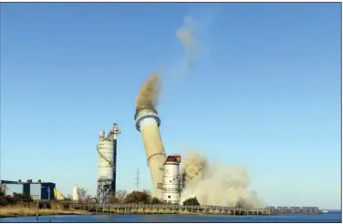  ?? (AP/Wayne Parry) ?? The smokestack at the former B.L. England power plant in Upper Township, N.J., is toppled during a control demolition on Thursday.