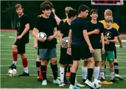  ?? DEBEE TLUMACKI/GLOBE STAFF ?? Carver senior captain Zachary Todd (far left) glances at the group of young players out for varsity this fall.