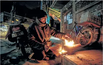  ?? SAMEER AL-DOUMY/GETTY IMAGES ?? A Syrian man boils a teapot in the rebel-held town of Douma, east of the Syrian capital Damascus. Syrian President Bashar Assad says the U.S. is welcome to join the battle against terrorists in the country, but that any U.S. participat­ion has to be in...