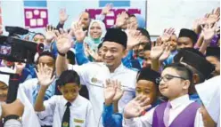  ?? BERNAMAPIX ?? Maszlee poses with teachers and pupils at SK Siputeh in Kedah during his visit yesterday.