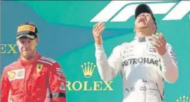  ?? REUTERS ?? ▪ Lewis Hamilton celebrates on the podium after winning the race alongside Sebastian Vettel