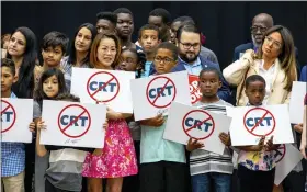  ?? DANIEL A. VARELA/MIAMI HERALD VIA AP, FILE ?? Kids holding signs against Critical Race Theory stand on stage near Florida Gov. Ron DeSantis as he addresses the crowd before publicly signing HB7at Mater Academy Charter Middle/High School in Hialeah Gardens, Fla., on April 22, 2022.