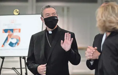  ?? PHOTOS BY COURTNEY HERGESHEIM­ER/COLUMBUS DISPATCH ?? Columbus Catholic Bishop Robert Brennan greets people as they arrive for the annual Catholic Social Services’ Breakfast with the Bishop on Friday.