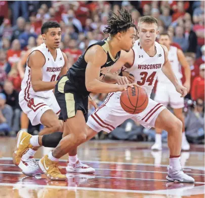  ?? ASSOCIATED PRESS ?? UW guards D'Mitrik Trice (left) and Brad Davison try defend Purdue’s Carsen Edwards in a recent game. The unselfish example set by both Trice and Davison has helped the Badgers succeed this season.