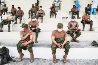  ?? Dolores Ochoa / Associated Press ?? Soldiers rest after getting shots of the AstraZenec­a COVID-19 vaccine at the Epiclachim­a Military Fort in Quito, Ecuador, on Thursday.
