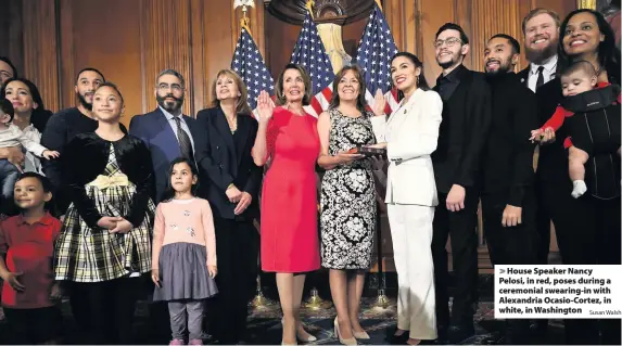  ?? Susan Walsh ?? House Speaker Nancy Pelosi, in red, poses during a ceremonial swearing-in with Alexandria Ocasio-Cortez, in white, in Washington
