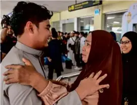  ?? CHAIDEER MAHYUDDIN/AFP VIA GETTY IMAGES ?? An Indonesian student evacuated from Sudan was greeted at the airport in Blang Bintang, Aceh, by his relatives Tuesday.