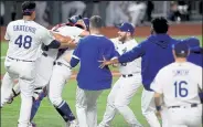  ?? TOM PENNINGTON / Getty Images ?? The Dodgers’ Austin Barnes, second from left, and Julio Urias, third from left, celebrate with teammates on the field after clinching the World Series over the Rays on Tuesday at Globe Life Field in Arlington, Texas.