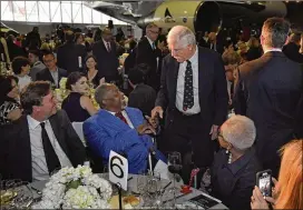  ?? HYOSUB SHIN / HSHIN@AJC.COM ?? Ted Turner (standing) talks to baseball legend Hank Aaron at the second annual Bill Foege Global Health Awards in May at the Delta Flight Museum. Seated at right is Billye Aaron. Turner has revealed he has Lewy body dementia.