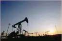  ?? Reuters ?? Pump jacks are silhouette­d against the rising sun at an oilfield in Baku, Azerbaijan. —