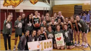  ??  ?? Bishop Shanahan players congratula­te Kathryn Greenhut after she scored her 1,000th career point Tuesday in the second quarter of the Eagles’ 55-37win against Avon Grove.