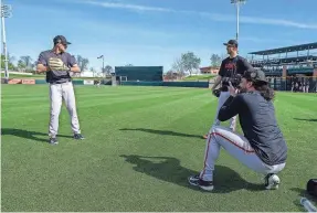  ?? MORRY GASH/AP ?? Giants teammate Sean Manaea takes pictures of Taylor Rogers, at left, and Tyler Rogers during a spring training workout Saturday.