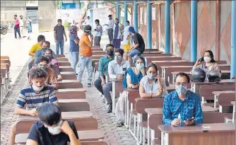  ?? SANJEEV VERMA/HT PHOTO ?? People wait for their turn to get vaccinated at the Govt Boys Senior Secondary School, Malviya Nagar, on Friday.