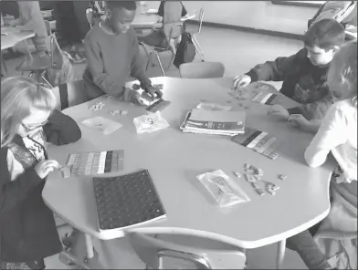  ??  ?? Fractions: In Alicia Risinger’s class, Junction City Elementary fourth graders Hadlei Cates, Jakorey Larry and Sam Yeager make equivalent fractions.