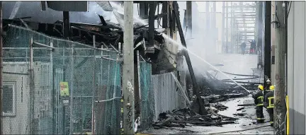  ?? WAYNE LEIDENFROS­T/PNG FILES ?? Firefighte­rs douse a fire on East Hastings Street in Vancouver on April 13.