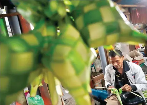  ?? AKHMAD KHUSAINI/JAWA POS ?? SAATNYA PANEN: Penjual bungkus ketupat di Pasar Pegirian menyambut momen kupatan yang biasanya berlangsun­g seminggu setelah Hari Raya Idul Fitri.