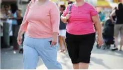  ?? — AFP ?? MARYLAND: Two women walk at the 61st Montgomery County Agricultur­al Fair Gaithersbu­rg, Maryland. The number of obese people has more than doubled in 73 countries since 1980 and has continued to rise in other countries, leading to a large increase in...