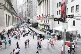  ??  ?? People walk outside the New York Stock Exchange. (AFP)
