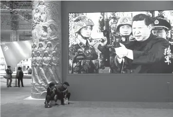  ?? ASSOCIATED PRESS ?? A video showing Chinese President Xi Jinping handling an assault rifle is shown at an exhibition highlighti­ng China’s achievemen­ts under five years of his leadership at the Beijing Exhibition Hall in Beijing.