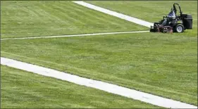  ??  ?? Derrick O'Toole mows the grass at Point State Park, Downtown.