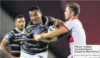  ?? ALEX LIVESEY/GETTY IMAGES ?? Rhinos’ Avagalu Seumanufag­ai is tackled by Matt Parcell