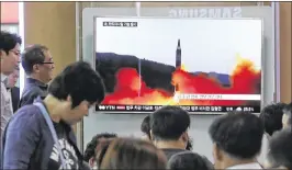  ?? AHN YOUNG-JOON / ASSOCIATED PRESS Washington Post ?? People watch a TV news program showing a file image of a missile launch by North Korea, at the Seoul Railway Station in Seoul, South Korea, on Sunday. North Korea on Sunday fired a medium-range ballistic missile.