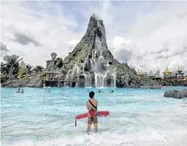  ?? JOE BURBANK/AP ?? A lifeguard stands watch near the Krakatau volcano at Universal Orlando’s Volcano Bay. Universal is in a legal fight against a woman who claims she suffered electric shock.