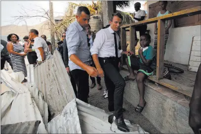  ?? Christophe Ena ?? The Associated Press France’s President Emmanuel Macron tries to find his way Tuesday during his visit to the Caribbean island of St. Martin.