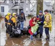  ?? BECKY MALEWITZ / SOUTH BEND TRIBUNE ?? Emergency workers use a boat Wednesday to help evacuate a northern Indiana resident amid flooding from melting snow and rain. Weather is blamed for hundreds of crashes and several fatalities.