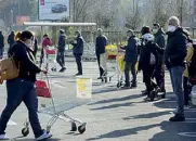  ??  ?? Code
In fila davanti a un supermerca­to per fare la spesa (Percossi/Ansa)