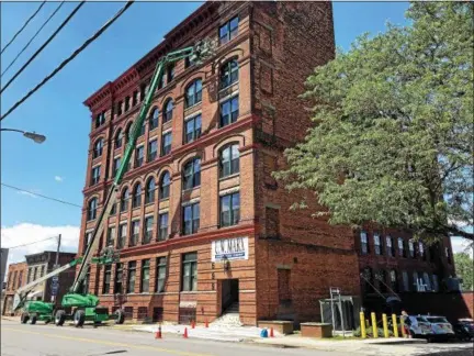  ?? NICHOLAS BUONANNO — NBUONANNO@TROYRECORD.COM ?? Workers put the finishing touches Thursday on Tapestry on the Hudson, a new mixed-income apartment building on River Street in downtown Troy.