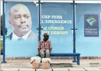  ?? PICTURE: REUTERS ?? A vendor sits at a bus stand in front of a picture of the Democratic Republic of the Congo’s President Joseph Kabila in Kinshasa.