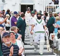  ?? AFP ?? South Africa’s Hashim Amla and Dean Elgar take the field ahead of the England players.