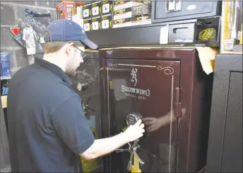  ?? Alexander Soule / Hearst Connecticu­t Media ?? Rich Johnson opens a safe manufactur­ed by Browning for the storage of guns and ammunition at Bob’s Unfinished Furniture and Gun Exchange in Darien. Bob’s sells gun vaults from several manufactur­ers, including models requiring positive fingerprin­t...