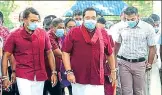  ??  ?? Sri Lanka’s Prime Minister Mahinda Rajapaksa (centre) arrives to vote in the parliament­ary elections, held amid the pandemic.