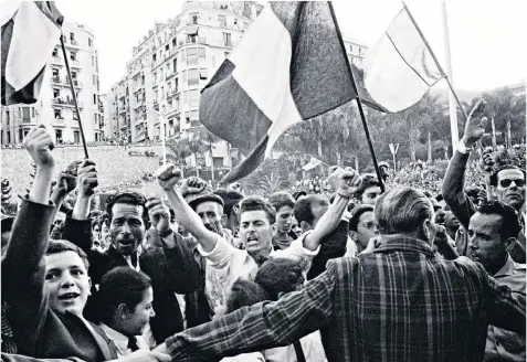  ??  ?? A demonstrat­ion in Algiers during the 1954-62 war, which led to the country gaining its independen­ce. Left, President Macron, with his wife Brigitte, met the widow of Maurice Audin and acknowledg­ed he had been executed or tortured to death