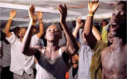  ??  ?? LOGRO. Migrantes a bordo del buque Open Arms celebran la noticia de que una orden judicial obliga a desembarca­rlos.