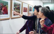  ?? WU KUANHONG / FOR CHINA DAILY ?? Photograph­y-loving senior citizens take a look at award-winning photos of a photograph­y competitio­n exhibited at the Shaanxi Library in October 2015.