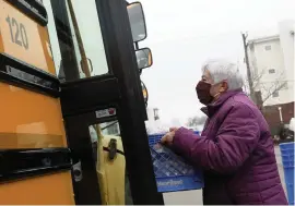  ?? KAITLIN MCKEOWN Virginia Media/TNS ?? Marge Moore, a bus driver for 49 years, loads food to deliver across the community outside Renaissanc­e Academy in Virginia Beach, Virginia.