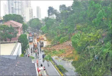  ?? ANSHUMAN POYREKAR/HT PHOTO ?? BMC workers clear the road after a landslide near Kemp’s Corner.